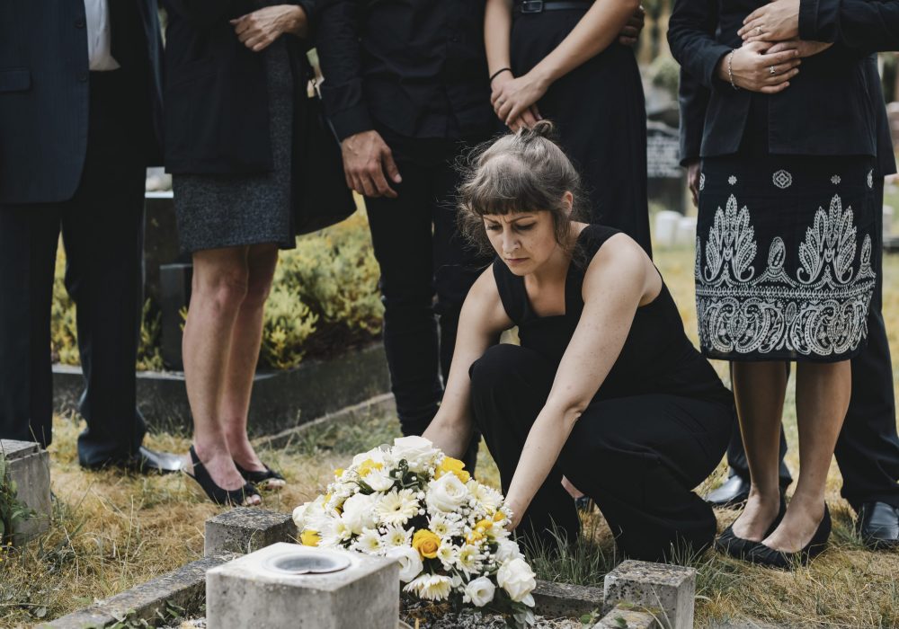 Family laying flowers on the grave Family laying flowers on the grave